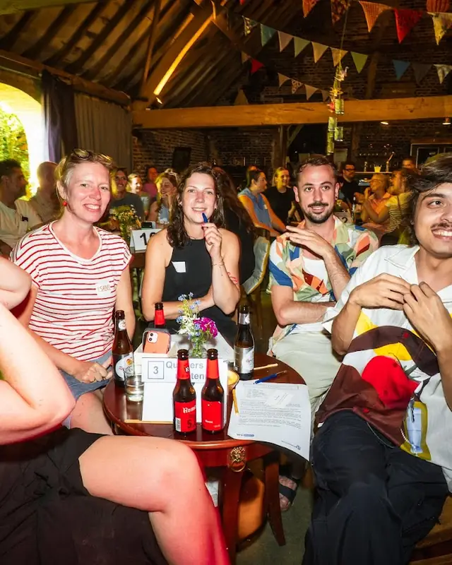 Een team aan tafel tijdens de quiz